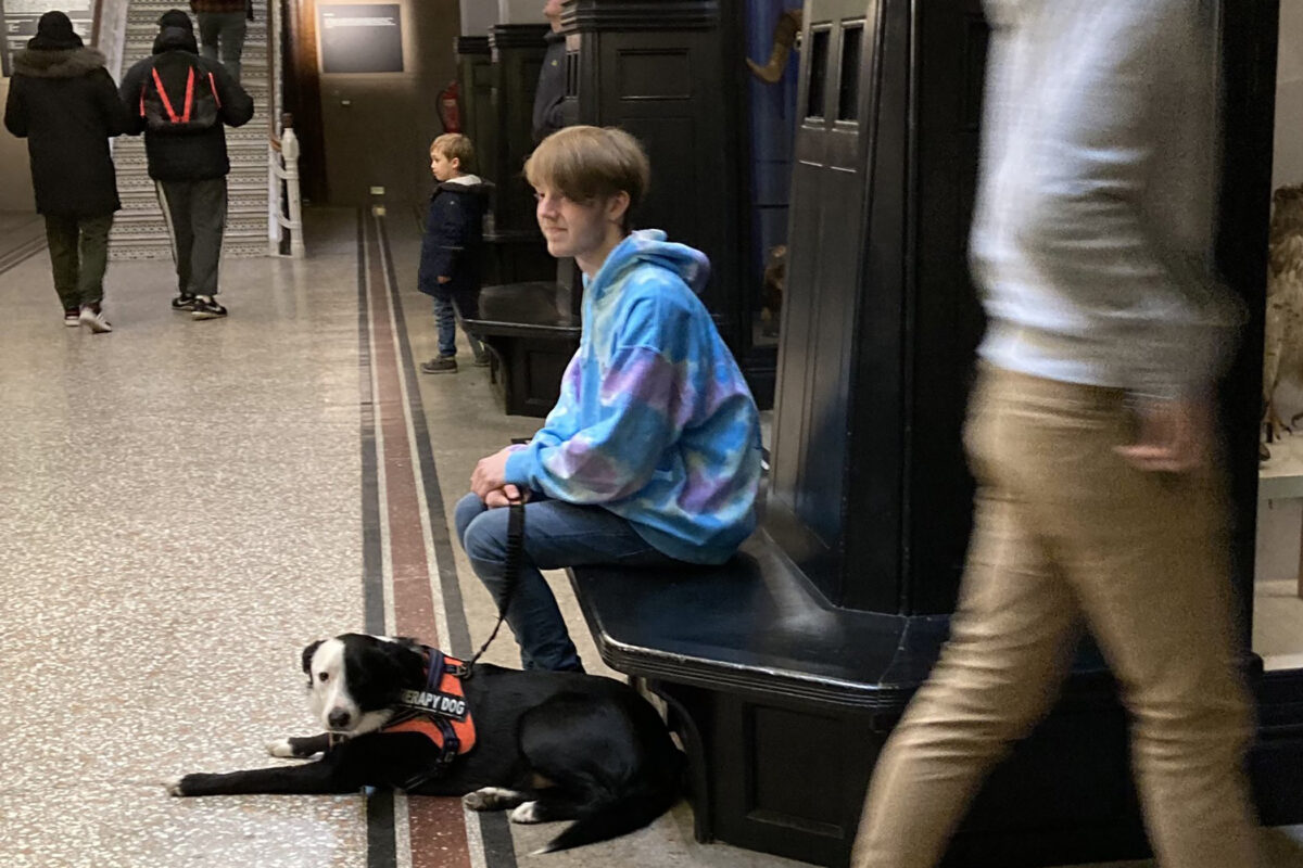 A therapy dog and a dog trainer sitting together in the Museum